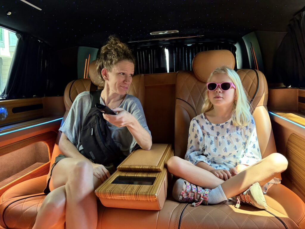 a woman and a girl sitting in a car with leather seating