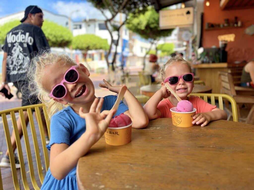 two girls eating gelato while wearing sunglasses
